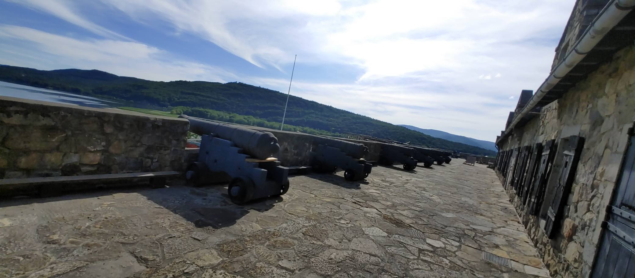 A cannon positioned along the fortification overlooking the surrounding landscape